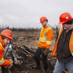 Foresters discuss wood waste in a pile